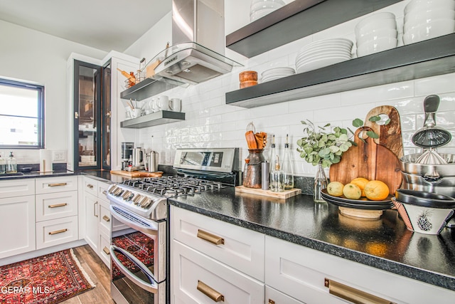 kitchen with range with two ovens, open shelves, tasteful backsplash, light wood-style flooring, and island range hood
