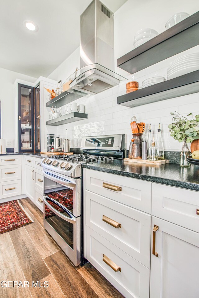 kitchen with light wood-style flooring, open shelves, white cabinets, island exhaust hood, and range with two ovens