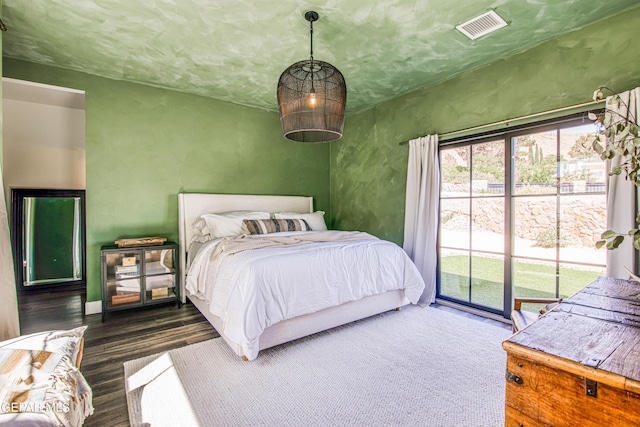 bedroom featuring visible vents, access to outside, and wood finished floors