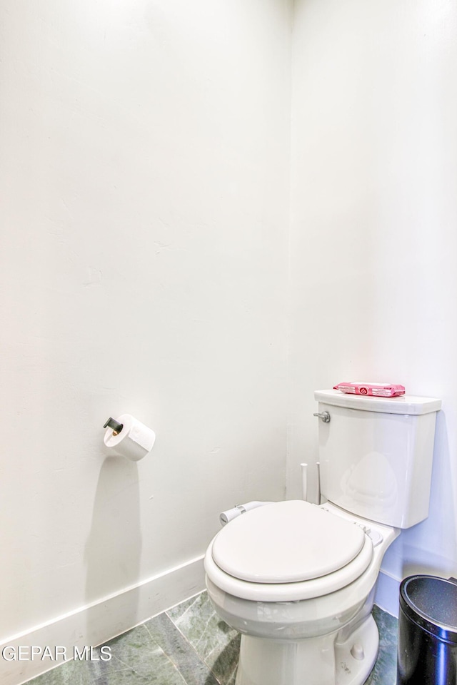 bathroom featuring toilet and baseboards