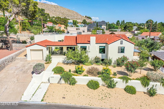 mediterranean / spanish home featuring a tile roof, driveway, a garage, and stucco siding