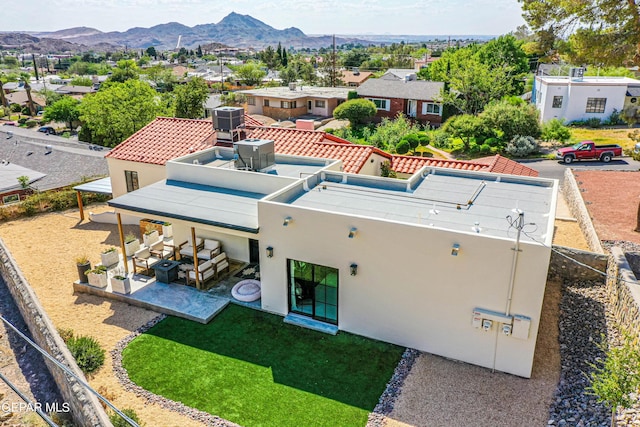 rear view of property with a patio, a residential view, a mountain view, stucco siding, and central AC