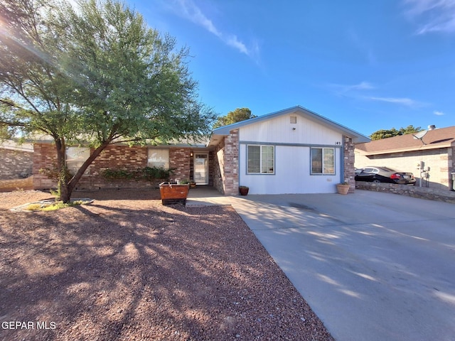 ranch-style house with concrete driveway and brick siding