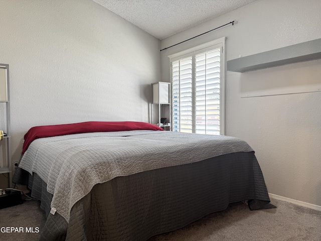 carpeted bedroom with baseboards and a textured ceiling