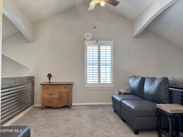 sitting room with a ceiling fan, a textured ceiling, arched walkways, vaulted ceiling, and carpet flooring