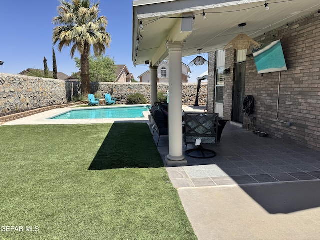 view of swimming pool with a yard, a patio, a fenced in pool, and a fenced backyard