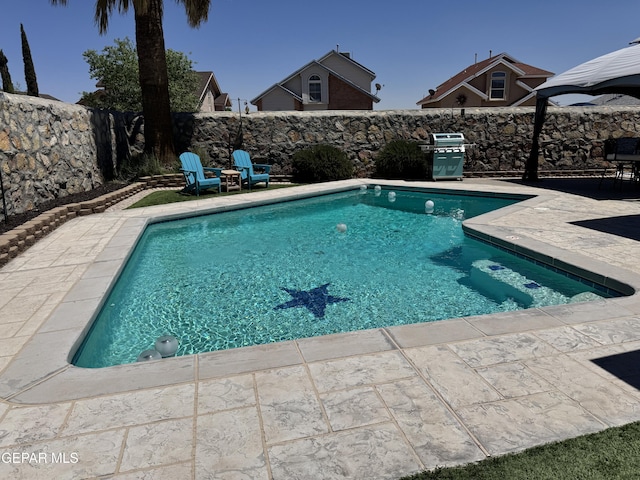view of pool featuring a patio, a fenced backyard, a fenced in pool, and a grill