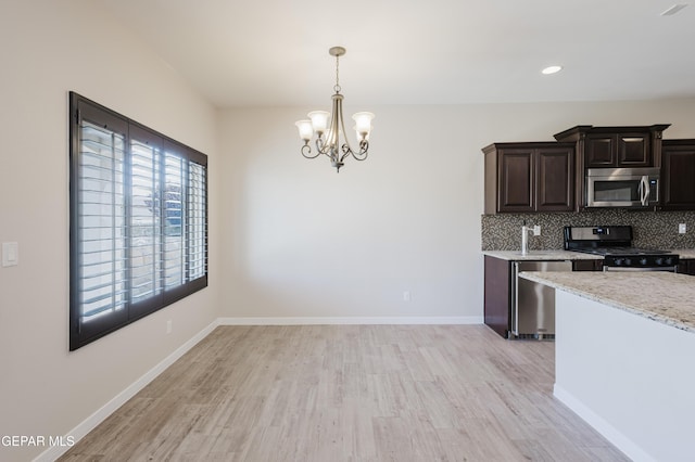 13145 Hazy, El Paso, TX 79938 - kitchen with appliances with stainless steel finishes, a chandelier, light wood-style flooring, backsplash, and recessed lighting
