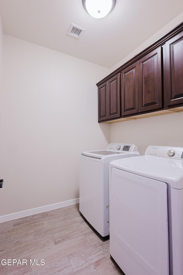13145 Hazy, El Paso, TX 79938 - laundry area featuring cabinet space, washer and dryer, and light wood-type flooring