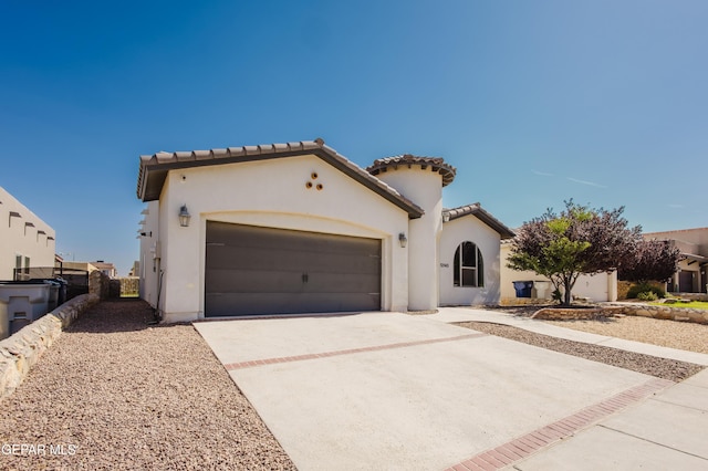 13145 Hazy, El Paso, TX 79938 - mediterranean / spanish-style house featuring concrete driveway, an attached garage, stucco siding, and a tile roof
