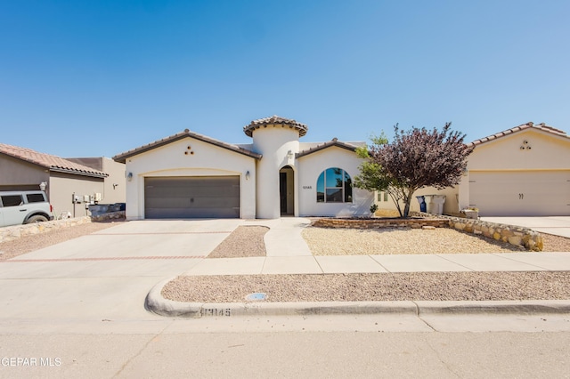 13145 Hazy, El Paso, TX 79938 - mediterranean / spanish-style home with a garage, driveway, stucco siding, and a tiled roof