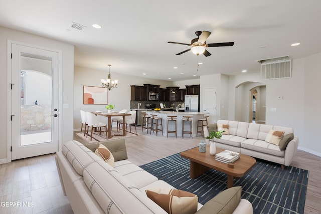 13145 Hazy, El Paso, TX 79938 - living room with arched walkways, a ceiling fan, recessed lighting, a chandelier, and light wood finished floors