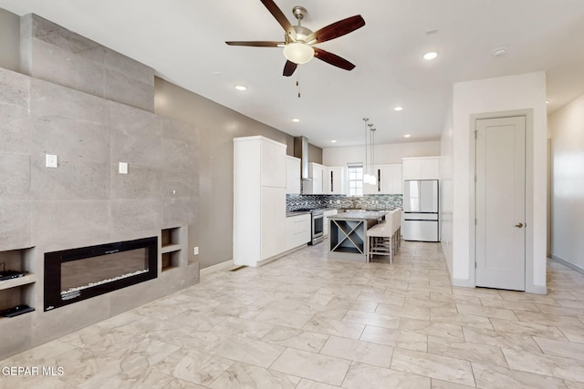 337 Vin Almoradi Ct, El Paso, TX 79912 - kitchen with built in features, a breakfast bar area, a ceiling fan, stainless steel stove, and freestanding refrigerator