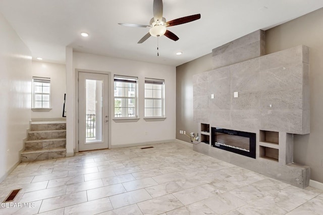 337 Vin Almoradi Ct, El Paso, TX 79912 - unfurnished living room featuring a wealth of natural light, ceiling fan, a tile fireplace, and baseboards