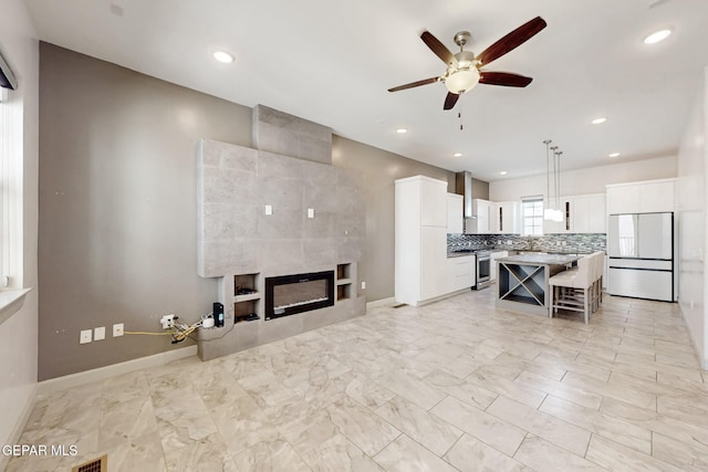 337 Vin Almoradi Ct, El Paso, TX 79912 - living area with ceiling fan, baseboards, a tile fireplace, recessed lighting, and marble finish floor
