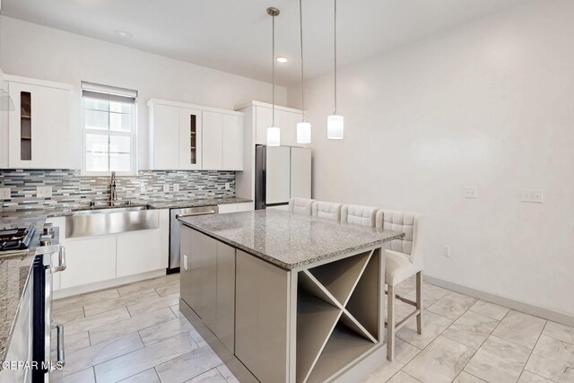 337 Vin Almoradi Ct, El Paso, TX 79912 - kitchen with a sink, stainless steel appliances, a center island, a breakfast bar area, and backsplash