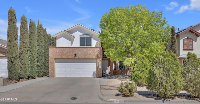 view of front of property featuring concrete driveway, an attached garage, and brick siding