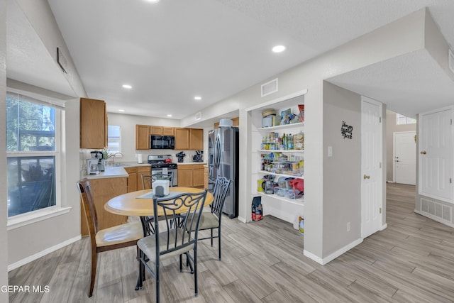 dining room featuring visible vents, light wood-style flooring, and baseboards