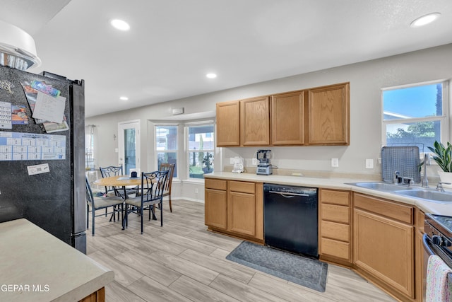 kitchen featuring recessed lighting, freestanding refrigerator, range, black dishwasher, and a sink