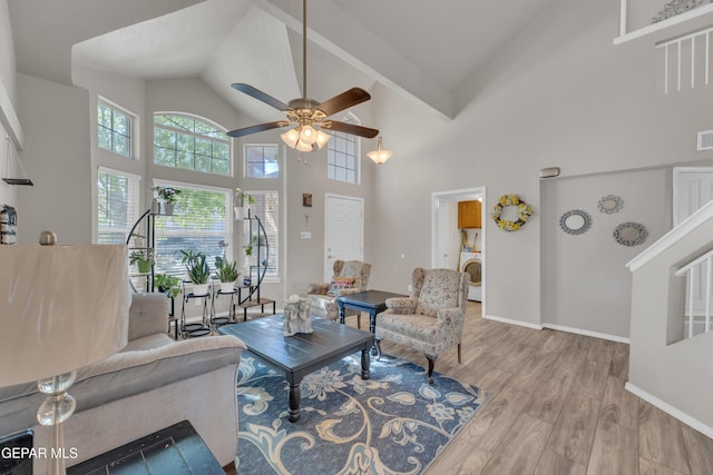 living room with wood finished floors, baseboards, high vaulted ceiling, washer / clothes dryer, and a ceiling fan