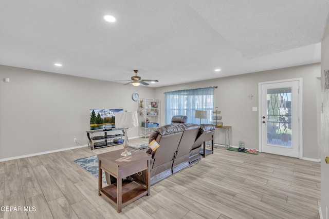living area with light wood-type flooring, a ceiling fan, recessed lighting, and baseboards