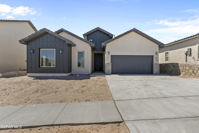view of front of house with board and batten siding, an attached garage, and concrete driveway