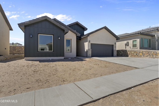 view of front of house with an attached garage, board and batten siding, and driveway