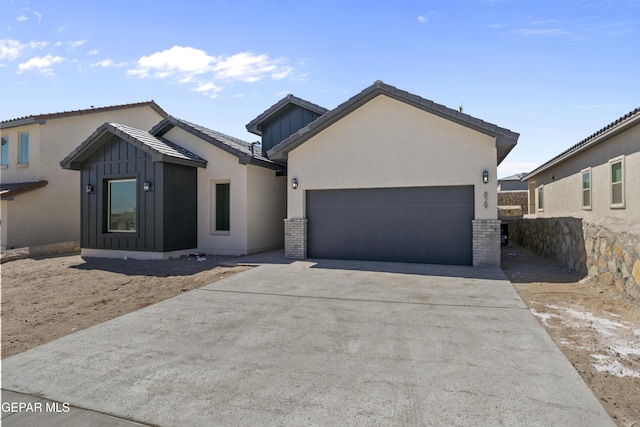 view of front of house with concrete driveway, an attached garage, board and batten siding, and stucco siding