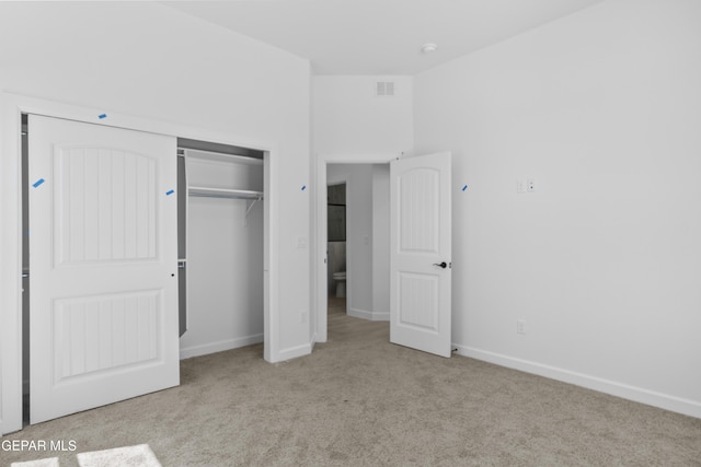 unfurnished bedroom featuring a closet, carpet flooring, baseboards, and visible vents