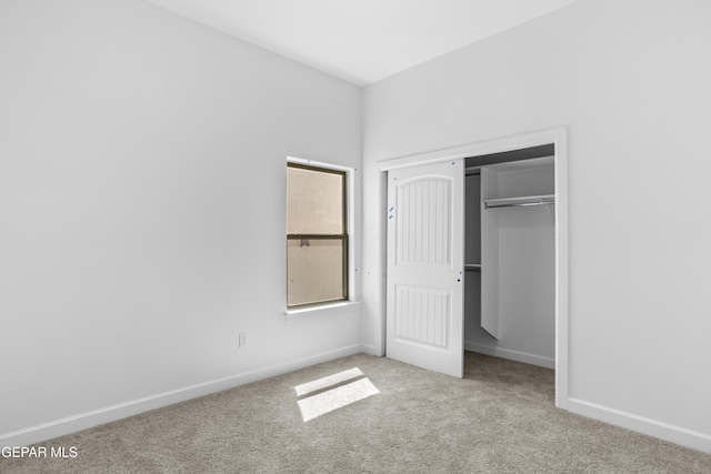 unfurnished bedroom with carpet flooring, baseboards, and a closet