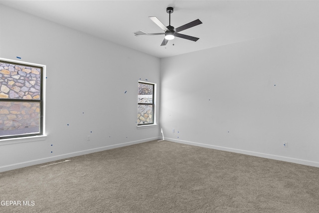 spare room featuring carpet floors, baseboards, and a ceiling fan