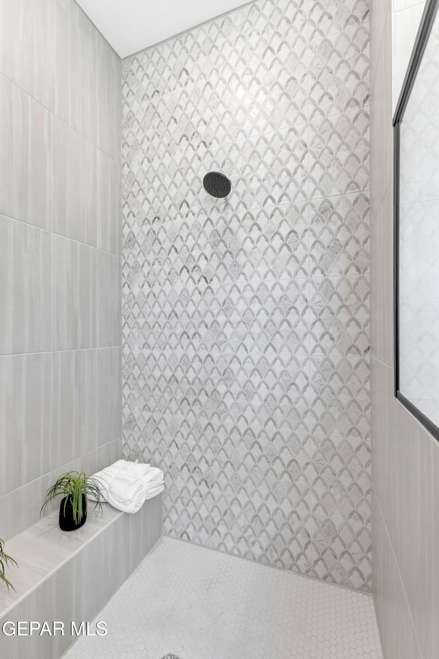 bathroom featuring tile walls and tiled shower