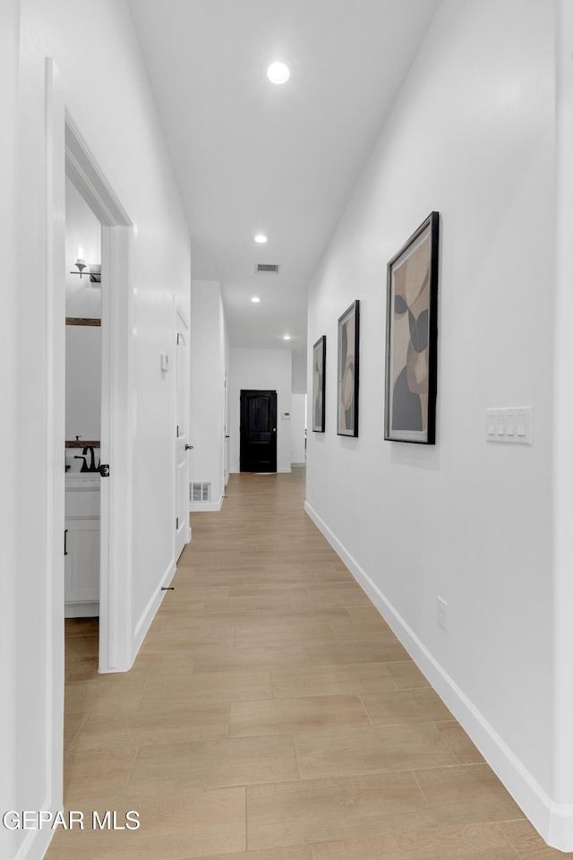 hall with recessed lighting, baseboards, visible vents, and light wood-type flooring
