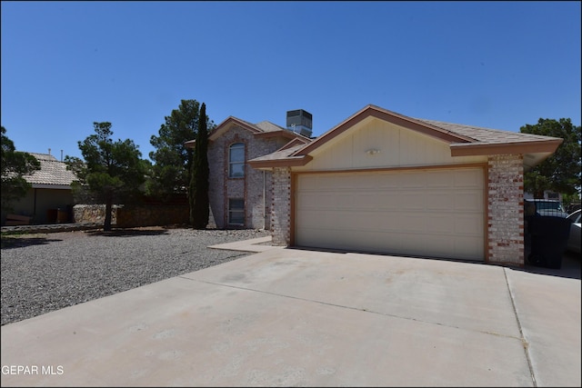 view of front of house with an attached garage, brick siding, and driveway