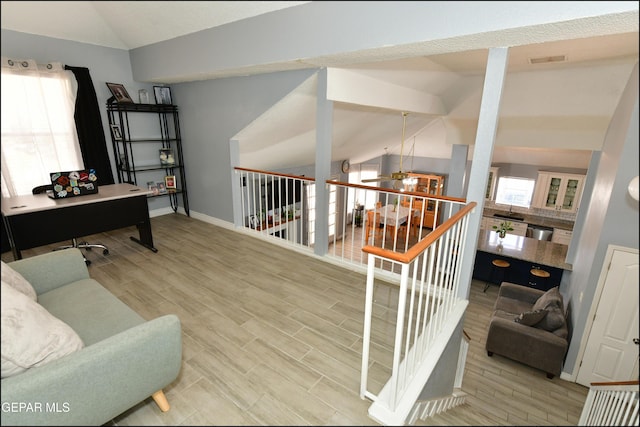 interior space featuring wood finished floors, lofted ceiling with beams, visible vents, baseboards, and ceiling fan