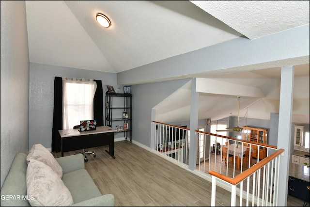 office space featuring lofted ceiling, baseboards, a ceiling fan, and wood finished floors