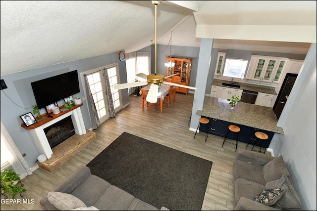 living room with vaulted ceiling, light wood-style flooring, and a wealth of natural light