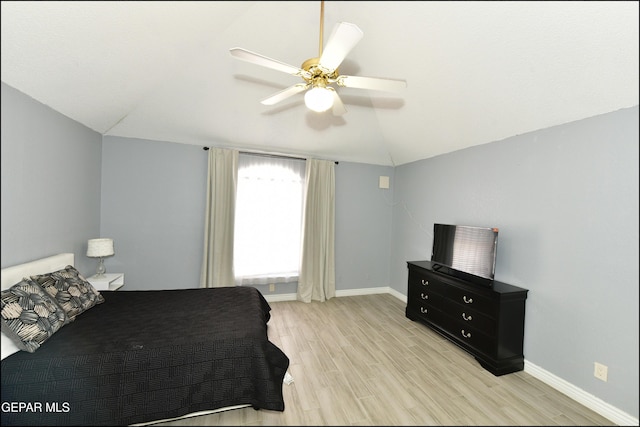 bedroom with a ceiling fan, vaulted ceiling, light wood-style flooring, and baseboards