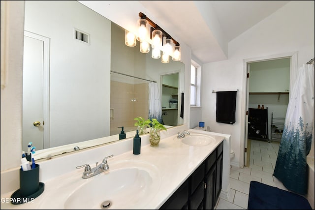 bathroom featuring a sink, lofted ceiling, visible vents, and tile patterned floors