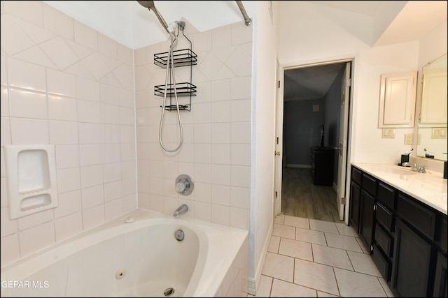 bathroom featuring a combined bath / shower with jetted tub, tile patterned flooring, baseboards, and vanity