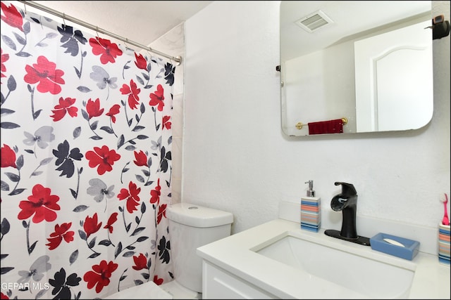 bathroom featuring toilet, a shower with curtain, visible vents, and vanity