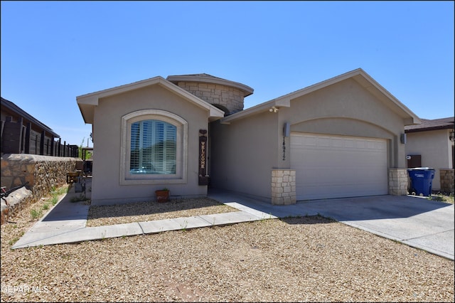 view of front of home with a garage, stucco siding, and concrete driveway