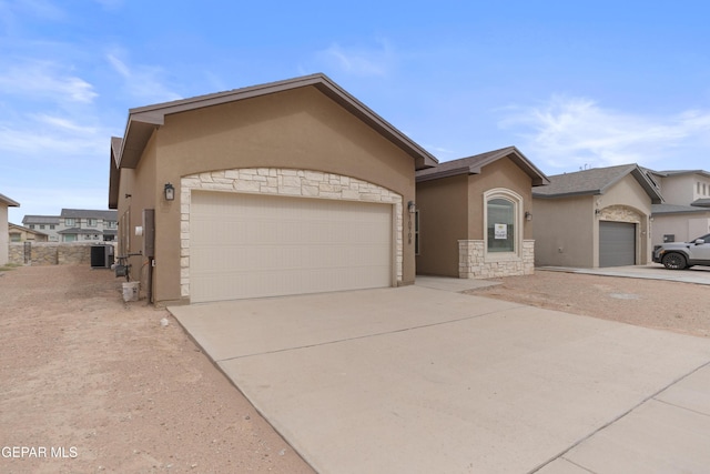 single story home with stucco siding, a garage, and driveway