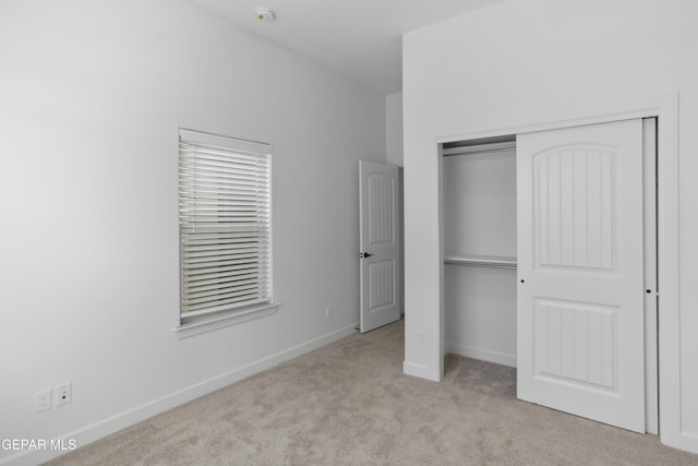 unfurnished bedroom featuring carpet, a closet, and baseboards