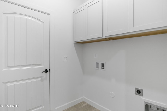 clothes washing area featuring cabinet space, hookup for an electric dryer, hookup for a washing machine, baseboards, and gas dryer hookup