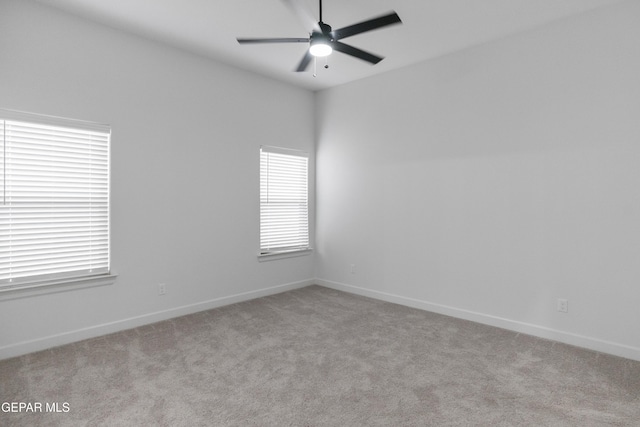 spare room with carpet, a ceiling fan, and baseboards