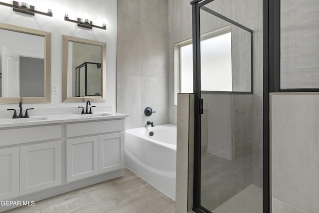 full bathroom featuring a stall shower, a garden tub, and double vanity