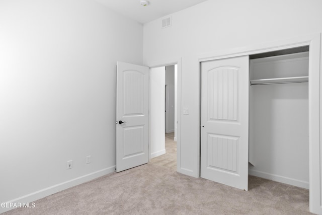 unfurnished bedroom with carpet, a closet, and baseboards