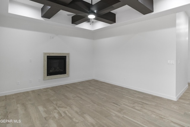 unfurnished room with wood finished floors, a glass covered fireplace, baseboards, and a ceiling fan