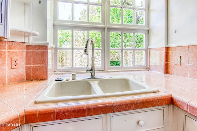 6041 Torrey Pines Dr, El Paso, TX 79912 - interior space featuring white cabinetry, backsplash, tile countertops, and a sink